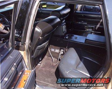 Car interior with black leather seats, wood trim, and a center console