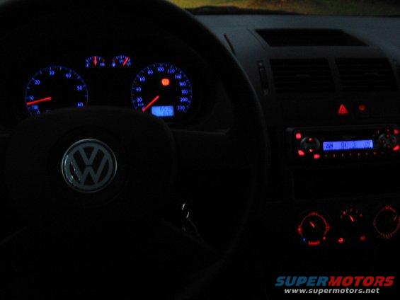 Interior dashboard of a 2002 Volkswagen Polo showing illuminated gauges and radio