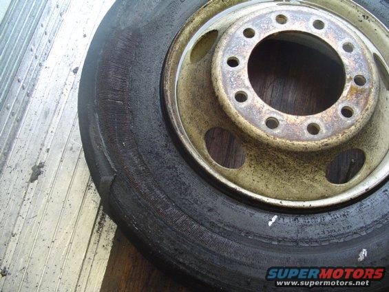 Worn tire and rim with visible damage
