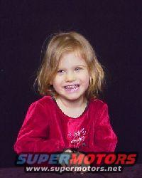 Young girl in red dress with blonde hair smiling