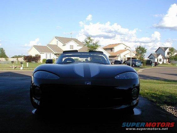 Black convertible sports car with dual silver racing stripes on the hood, viewed from the front
