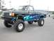 1994 Ford Bronco - This heavily modified pickup truck features a custom paint job and an elevated suspension system with oversized tires.