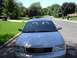 1999 Audi A6 - The front grille and headlights of a silver 1999 Audi A6 sedan are visible in this street scene.