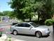 1999 Audi A6 - A silver sedan is parked on a driveway with trees and a street visible in the background.
