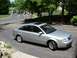 1999 Audi A6 - This silver 1999 Audi A6 sedan is seen from a 3/4 front angle on a paved driveway, with another vehicle in the background.
