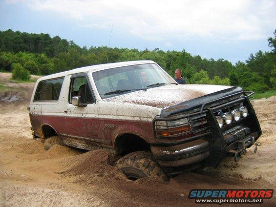 Ford Bronco stuck in sand, front bumper has lights and winch