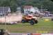 1979 Ford Bronco - Monster truck jumps over destroyed cars at an event with spectators watching.