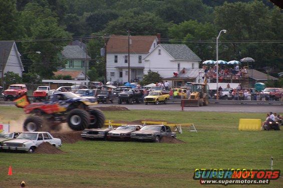 Monster truck mid-air jump over crushed cars