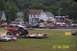 1979 Ford Bronco - A monster truck soars through the air over a line of cars during an event.