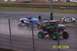 1979 Ford Bronco - Monster trucks compete on a dusty track, kicking up dirt as they race past the fence.