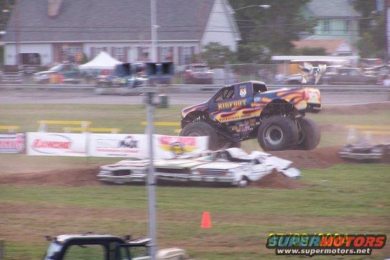 Monster truck named Bigfoot jumps over wrecked cars in a dirt arena
