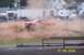 1979 Ford Bronco - A red pickup truck races through dirt, creating a massive dust cloud during an event.