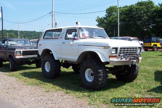 White lifted 1978 Ford Bronco with large tires and a winch on the front bumper