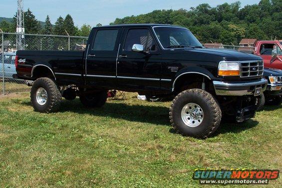 Black Ford F-250 pickup truck with large tires, lifted suspension, and chrome accents