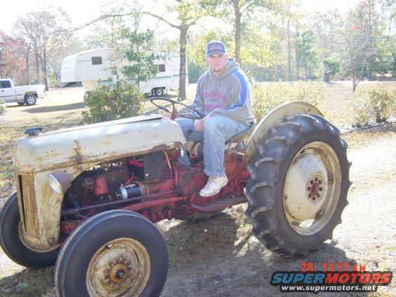 Old red and white tractor with a man sitting on it