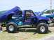1994 Ford Bronco - This heavily modified Toyota pickup truck features a custom paint job and lifted suspension, with its bed and doors open.