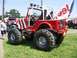 1994 Ford Bronco - A modified red Jeep with patriotic paint and a large flag is parked on grass.