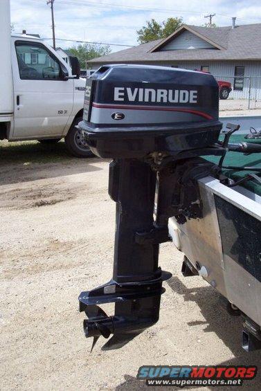 Evinrude outboard motor mounted on the back of a boat, with a white box truck in the background