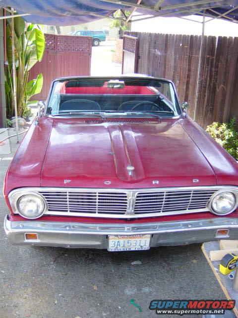 Red 1965 Ford Ranchero convertible front view, chrome grille, visible license plate