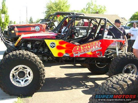 Off-road buggy with flames and "4 Wheel Parts" text, 3q-front view