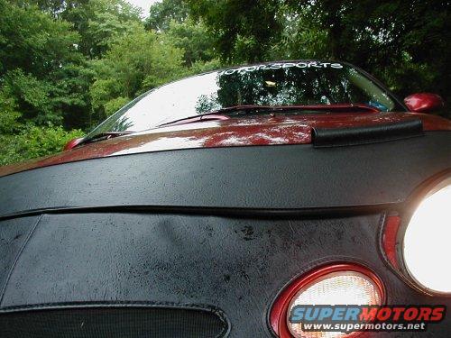 Red car with bra and "MOTOR SPORTS" windshield banner