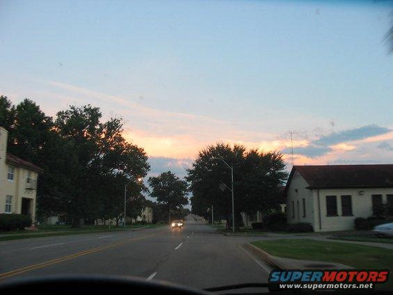 Roadside view of buildings and trees during a sunset