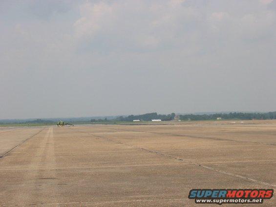 Yellow vehicle on airport tarmac, distant view