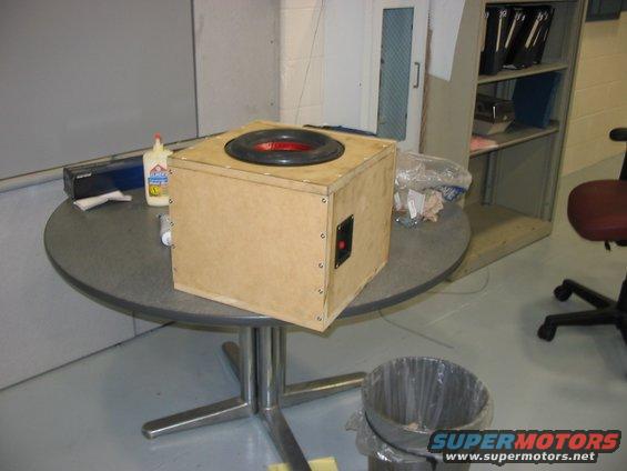 Wooden speaker box with red and black accents on a round table