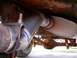 1978 Ford Bronco - Close-up view of a vehicle's exhaust system and rear axle, with visible text from a website.