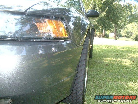 Dark gray 2003 Ford Mustang side view showing front fender, headlight, and tire