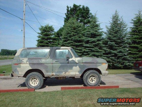 Camouflaged SUV with 'HILLBILLY' written on the side, parked on pavement