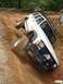 1984 Ford Bronco - A Jeep gets stuck on a steep, muddy incline during an off-road excursion.