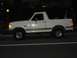 1988 Ford Bronco - A white Ford Bronco is seen from the side at night, parked on a street.