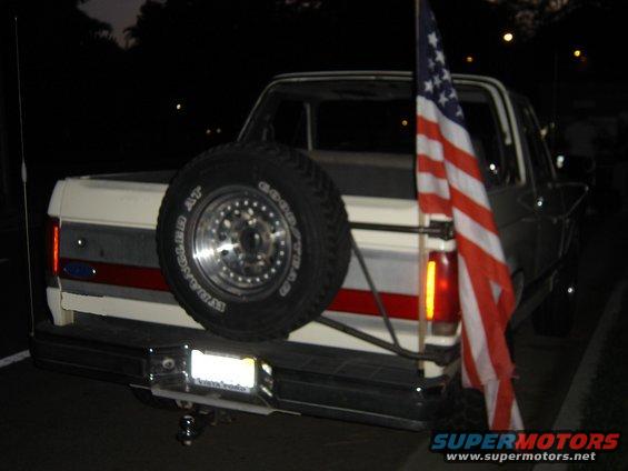 1987 Ford Bronco rear view with spare tire mounted on the back and an American flag attached