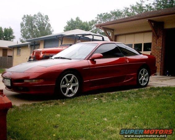 Red 1994 Ford Probe coupe with black hood parked in driveway