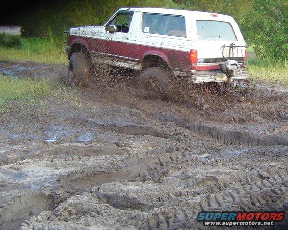 Ford Bronco kicking up mud while driving off-road