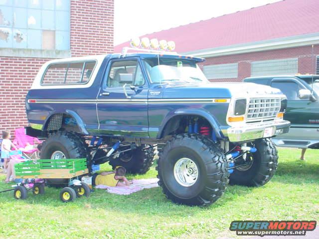 Lifted blue 1978 Ford Bronco with a white top, chrome grille, and large tires