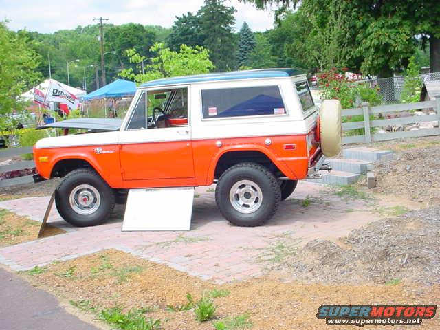 Orange and white 1979 Ford Bronco parked on brick pavers