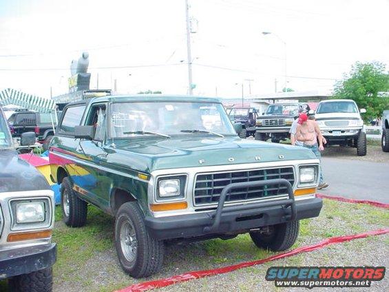 Green Ford Bronco with a black bull bar and yellow/pink accents on the side