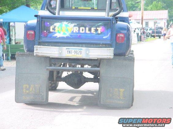 Rear view of a blue Chevrolet pickup truck with "CHEVROLET" on the tailgate and large CAT mud flaps