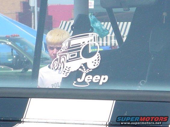 Jeep sticker on a dark window with a person visible behind it