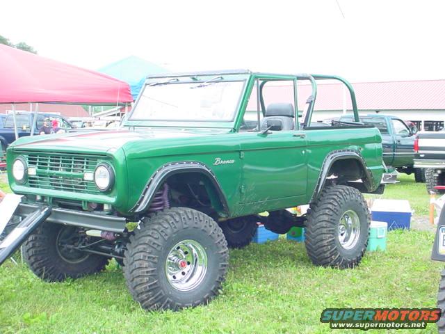 Green 1978 Ford Bronco with lifted suspension and large tires, parked on grass