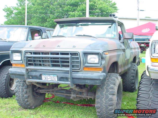 Front view of a camouflaged 1979 Ford Bronco with a brush guard and large off-road tires