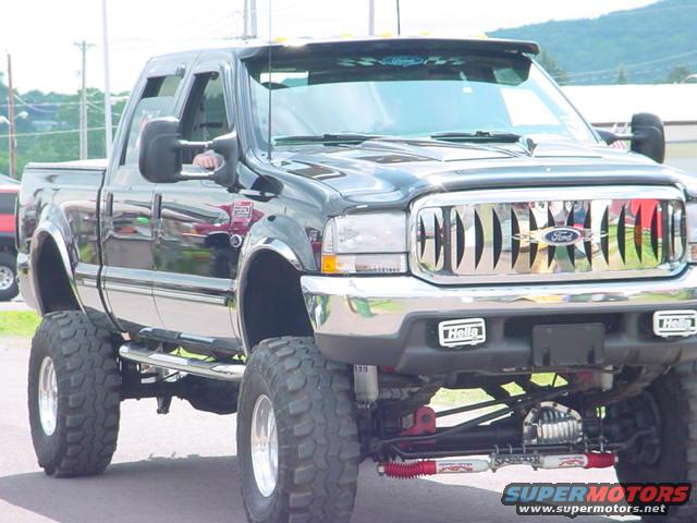 Lifted black Ford pickup truck with chrome grille and large tires
