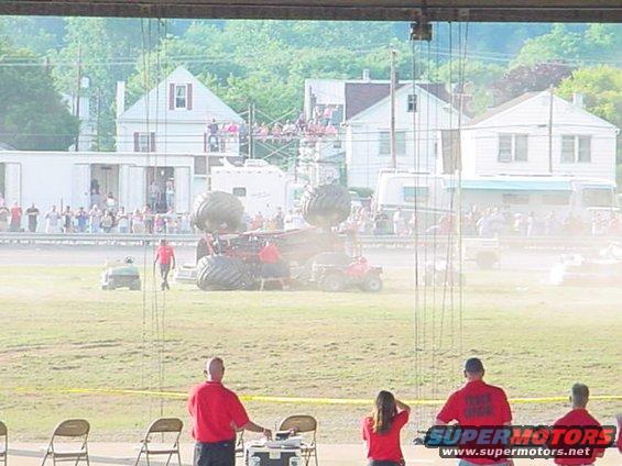 Monster truck with oversized tires on display, with spectators in the background