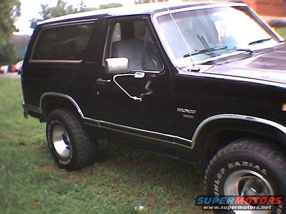 1986 Ford Bronco side view, black paint, chrome trim, on grass