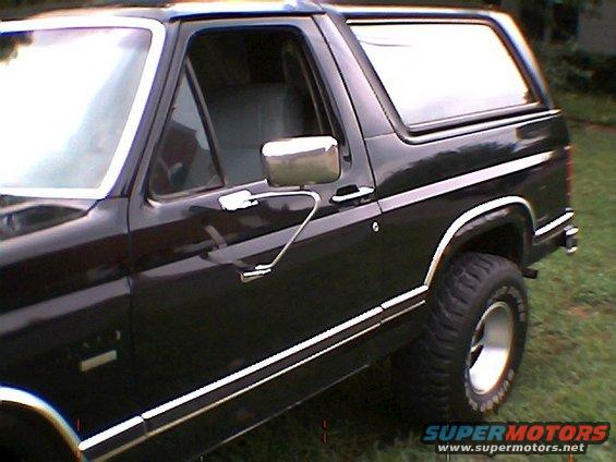 black SUV, side view, showing door, mirror, and tire