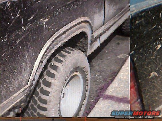 Mud-splattered black Ford Bronco side view, showing fender and tire