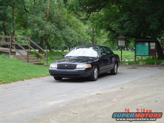 Black 1999 Ford Crown Victoria sedan parked on a paved road