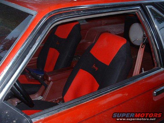 1984 Ford Mustang interior showing red and black seats with 'Foxxy' embroidery